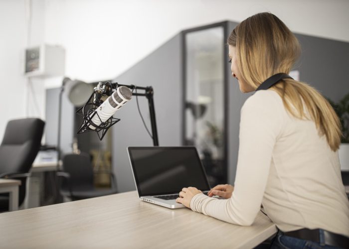 smiley-woman-doing-radio-with-laptop-microphone