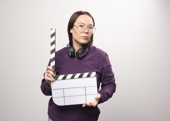 Young woman holding a cinema tape on a white background . High quality photo